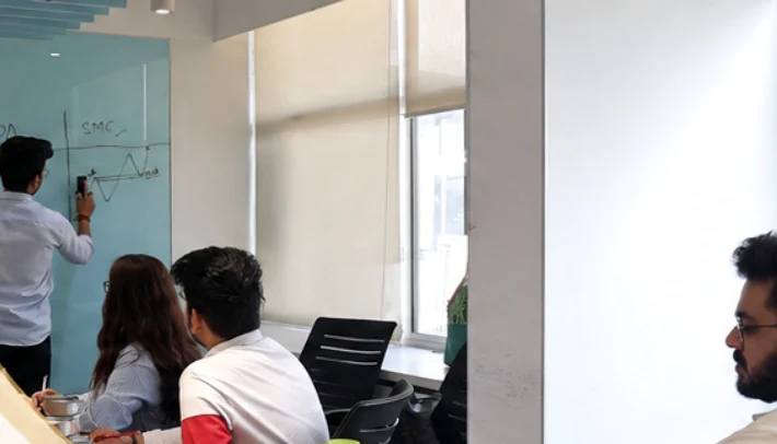 Students participating in an in-person trading mentorship discussion